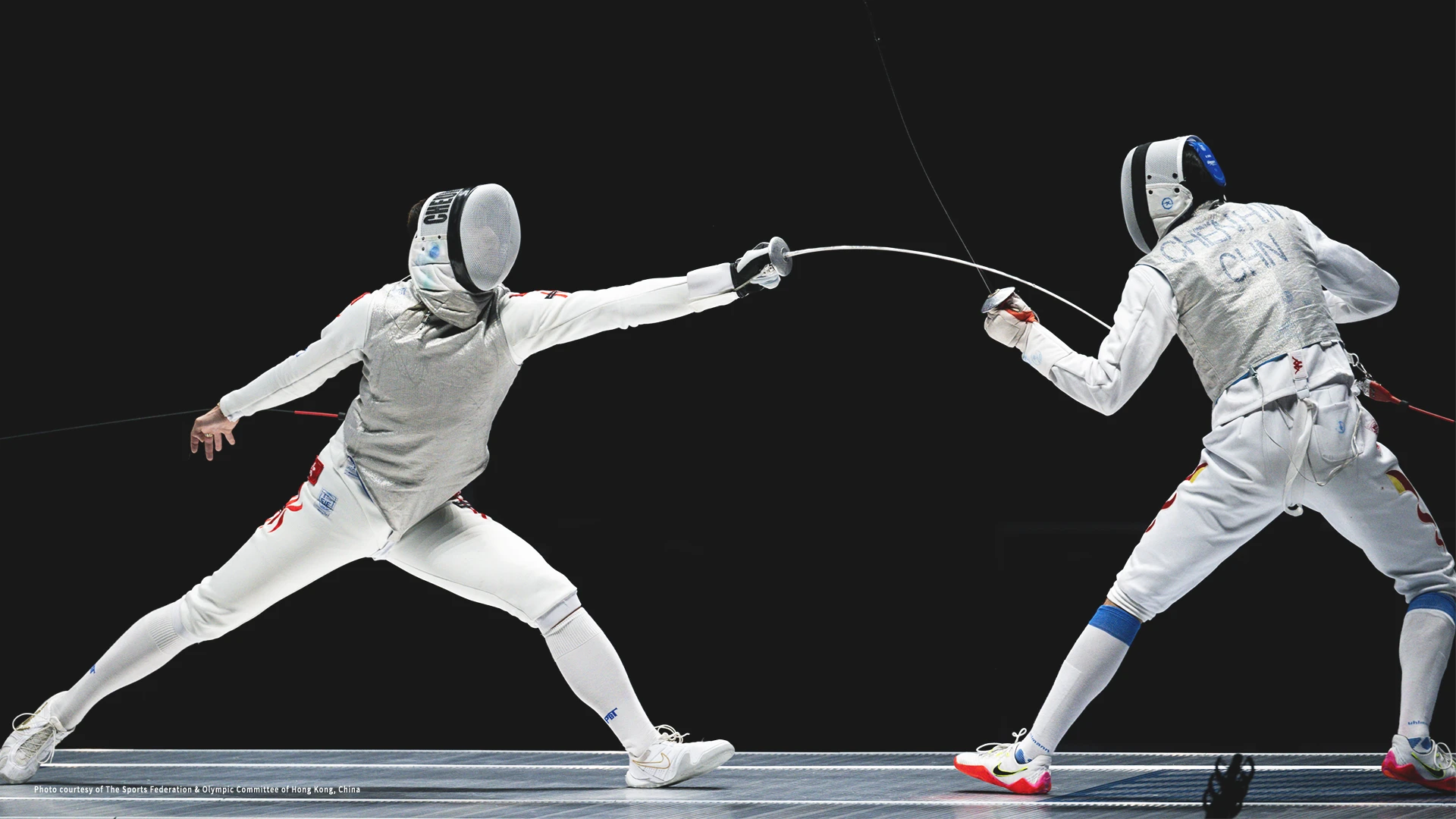 Two fencing competitors competing in a fencing event.